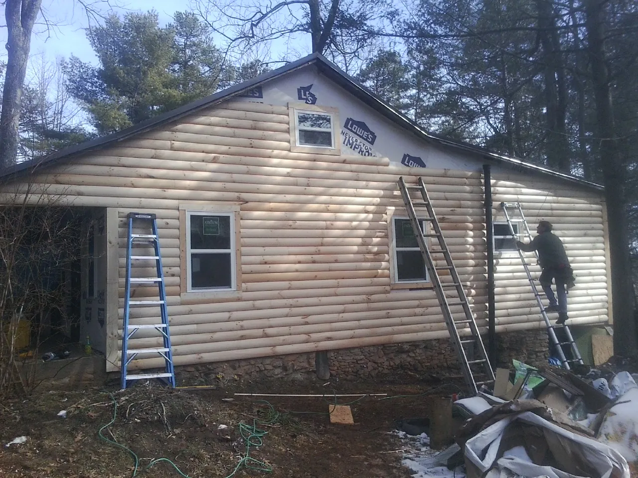 Ladders set against fresh log siding during an exterior remodel in Omaha