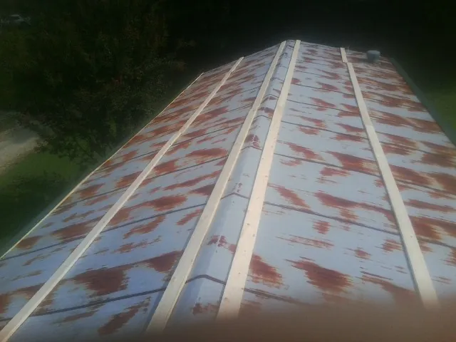 Rusted metal roof panels with new wood purlins before replacement — Storm Damage Roof Repair in Omaha by Roofing Brothers