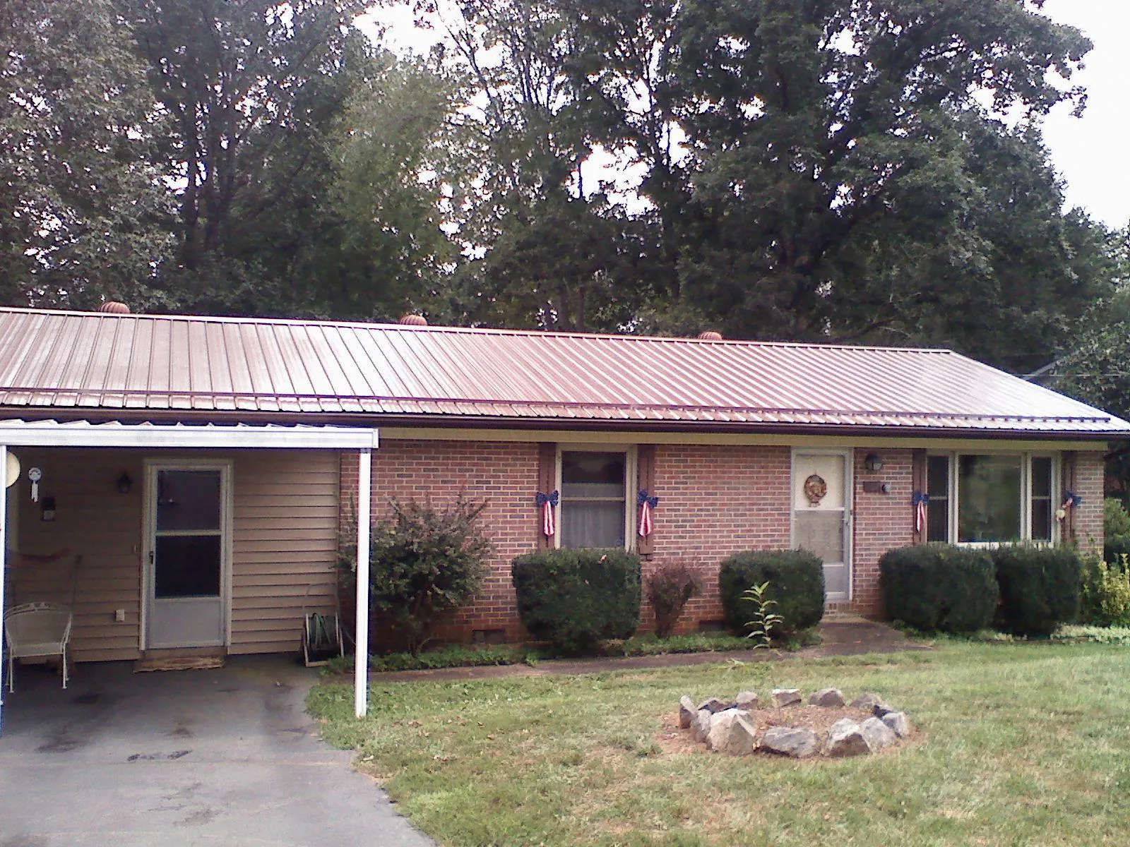 Bronze metal roof and carport on a brick ranch home — Roof Repair work by our crew in Omaha
